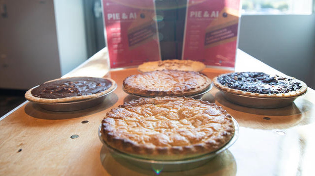 Five pies arranged on a table during a Pie & AI event.